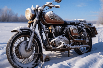 깊은 겨울에 서리가 앉은 오토바이 배터리와 차가운 공기 속 보이는 탑승자의 좌절한 한숨이 어우러진 모습이다.